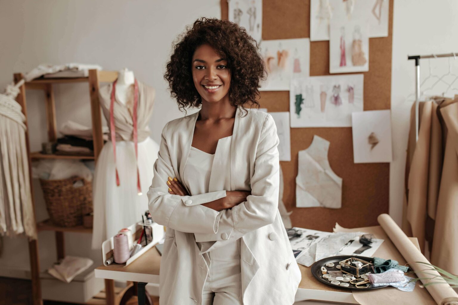 beautiful-curly-brunette-dark-skinned-fashion-designer-poses-office-leans-table-min-1-1-1536x1024-1