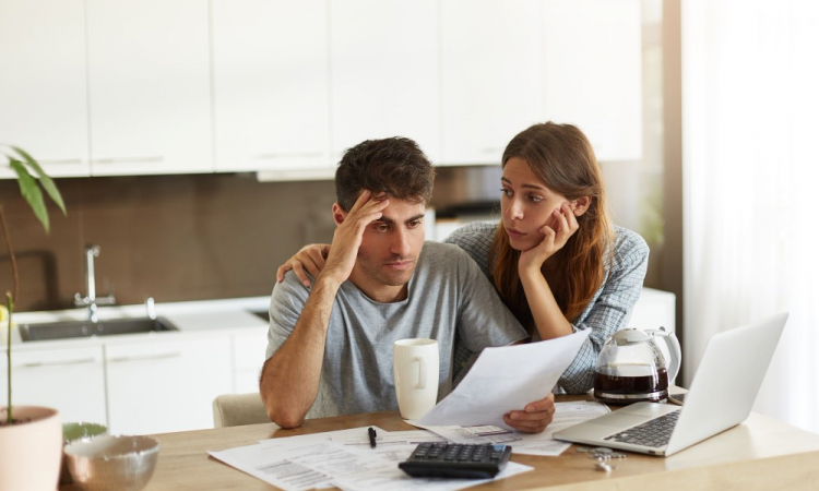 young-couple-checking-their-family-budget-750x450